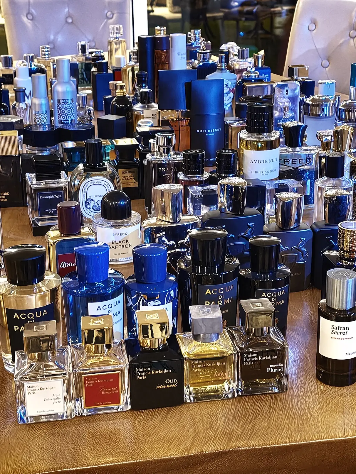 A personal fragrance collection arranged across a wooden table